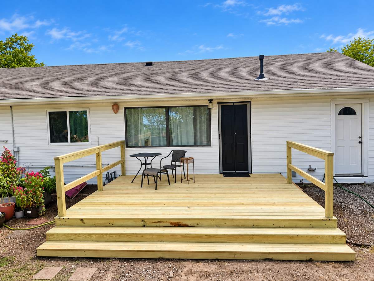 Ground-level wood deck with railing on a ranch home