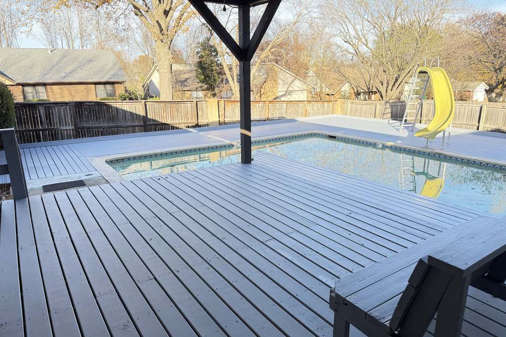 Timber pavilion with a solid roof over a composite pool deck